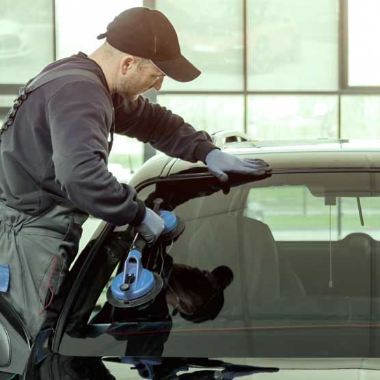 A Northern Lites Auto Glass technician replacing a car windshield in Manitoba