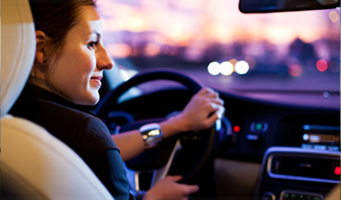 Woman driving a car with a new windshield installed