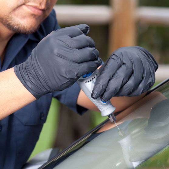 A Northern Lites Auto Glass technician repairing a windshield in Thompson, Manitoba